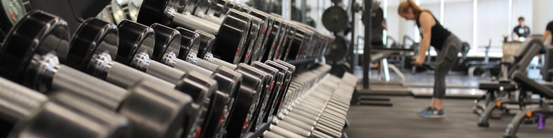 现代化商业健身俱乐部内部，会员使用智能器械